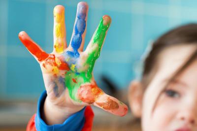 child with paint on hand for fingering painting